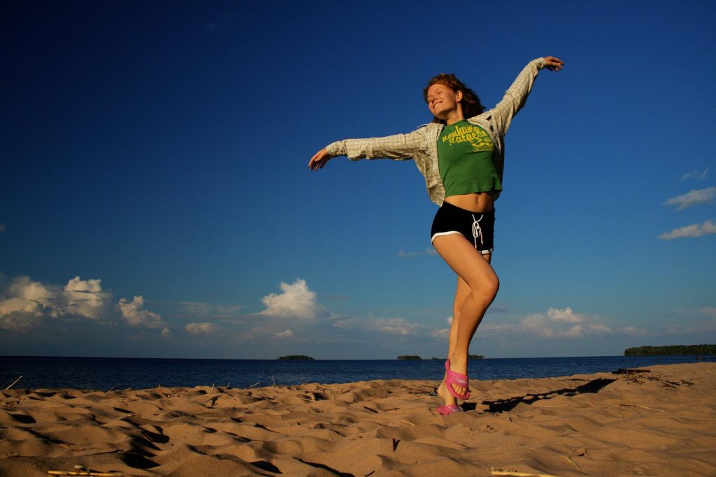 A person holding a frisbee on a beach

Description automatically generated